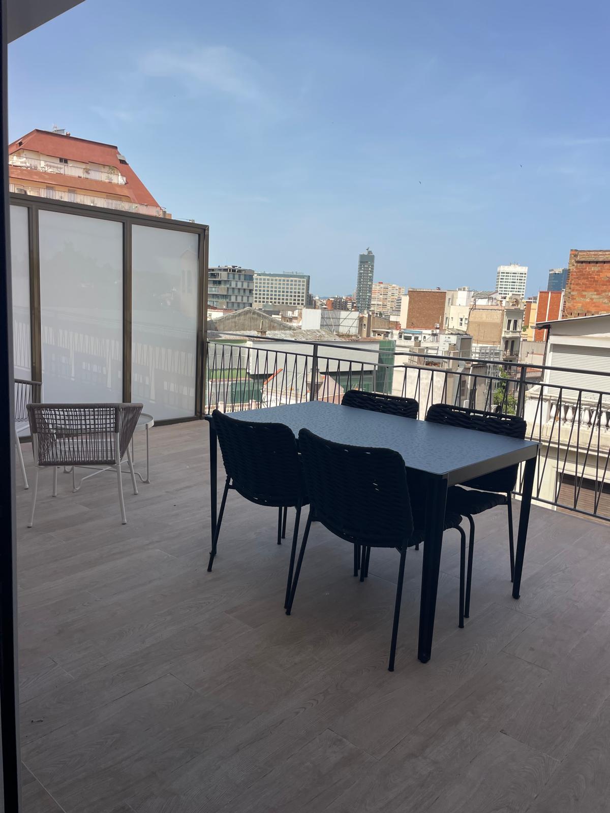 Terrassa reformada amb paviment porcellànic nou i vistes a Barcelona des de Sants