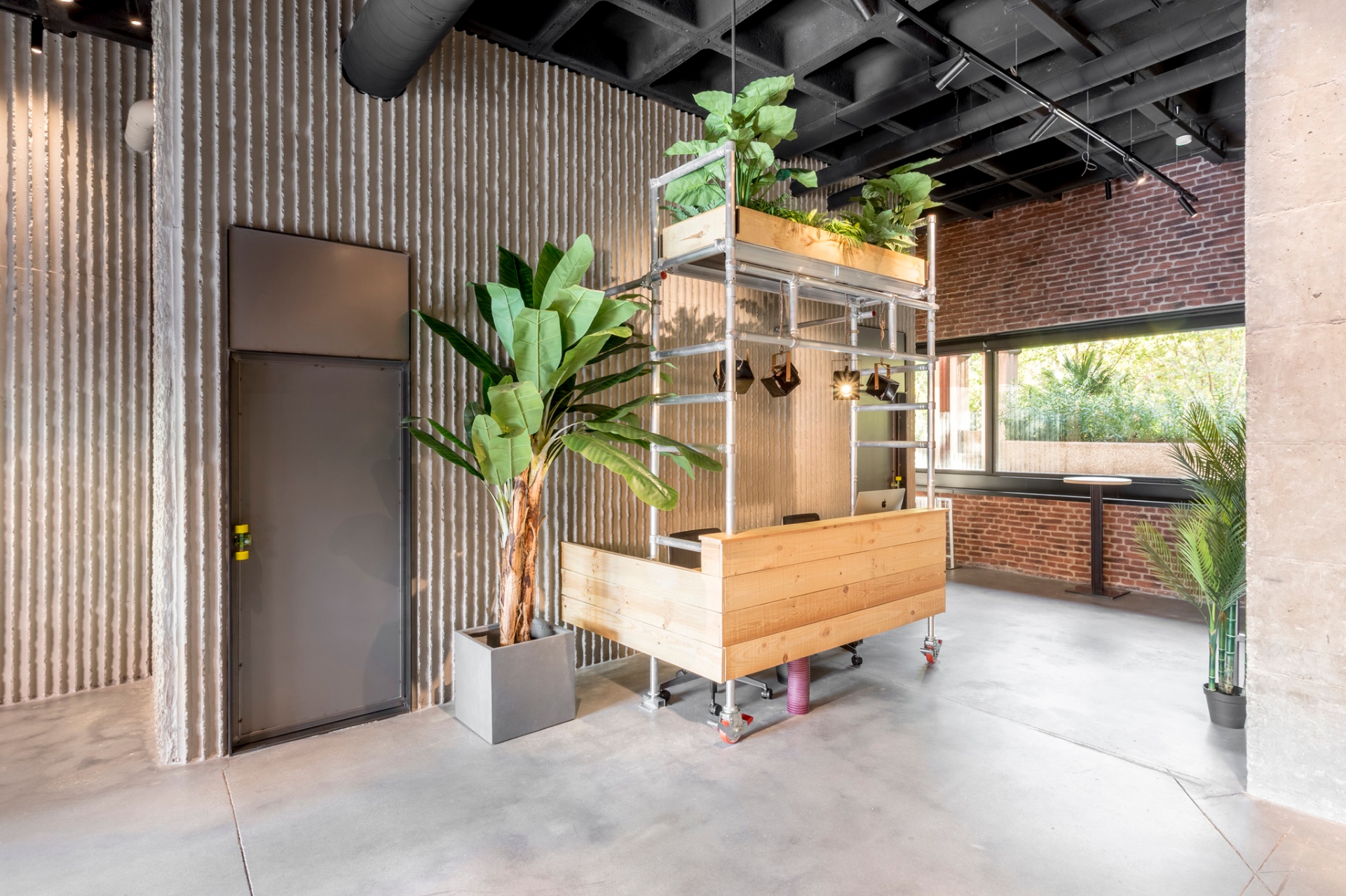 Reforma de local comercial de estilo industrial en Vilafranca del Penedès (Alt Penedès) con recepción de madera, estructura metálica y pared de ladrillo visto