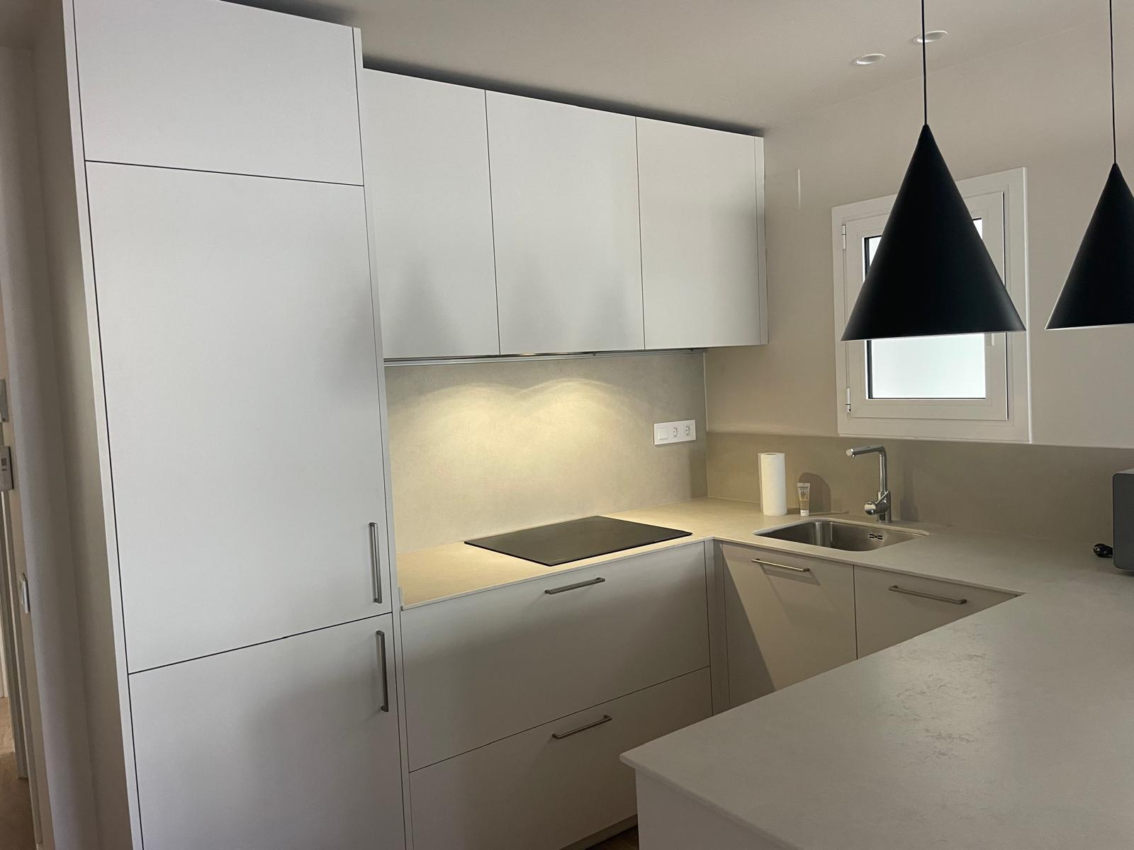 Detall de la cuina reformada amb placa d'inducció a Barcelona Sants