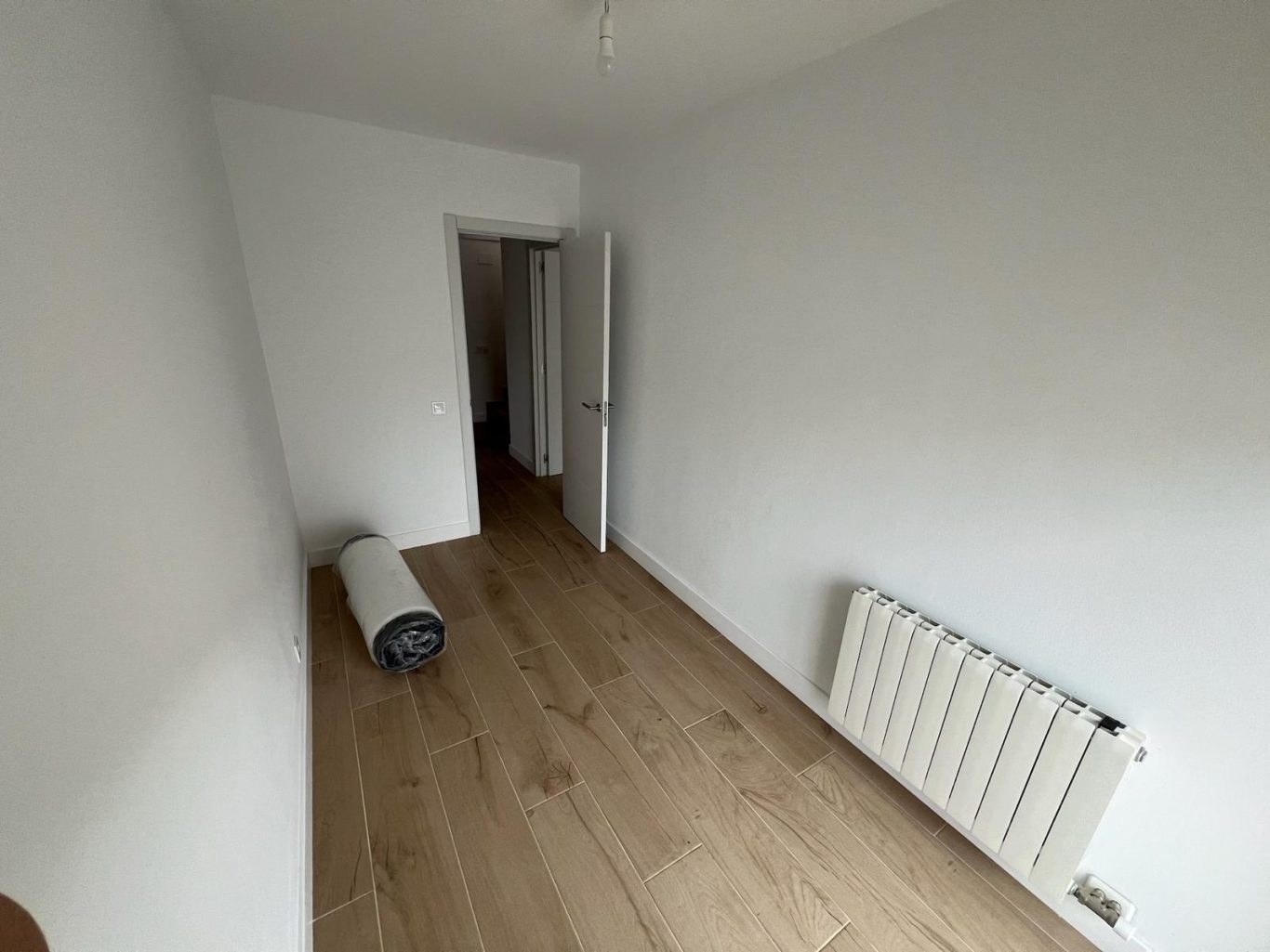 Reformas Vilafranca - habitació pintada blanca amb radiador